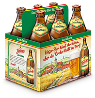 Sechs Bierflaschen in einem Karton mit einer Bauernhofgrafik auf der Seite.